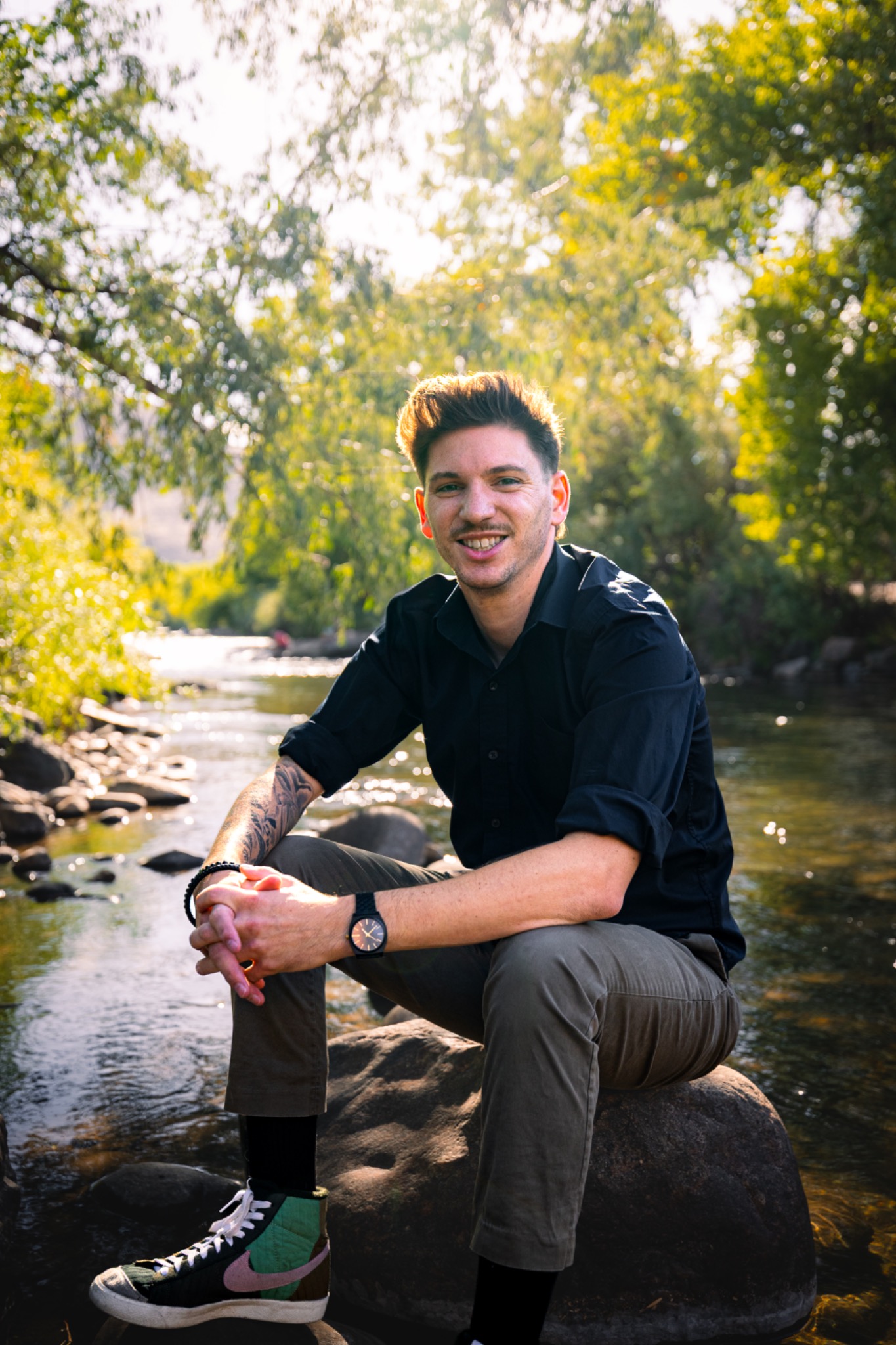 Benjamin Kay, owner of Isolated Bodywork, seated beside a Colorado river