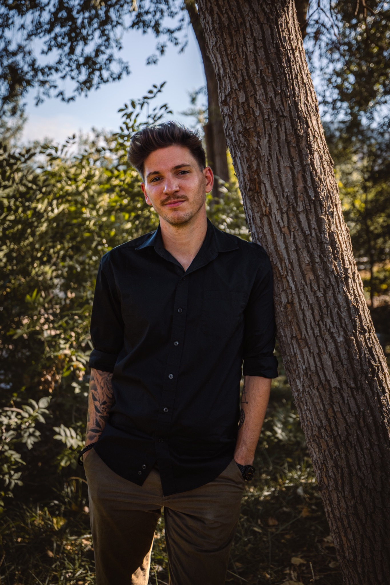 Benjamin Kay, owner of Isolated Bodywork, standing beside a tree outdoors